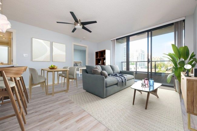 Living area featuring expansive windows, a textured ceiling, light wood-style flooring, and a ceiling fan | Image 7
