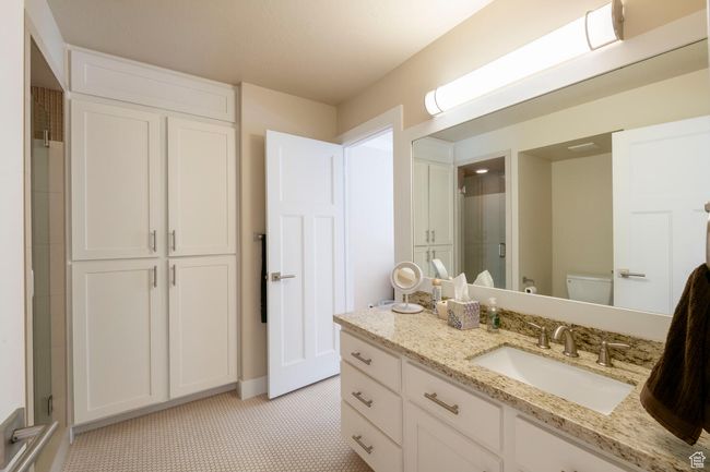 Bathroom featuring baseboards, toilet, vanity, tile patterned floors, and a stall shower | Image 12