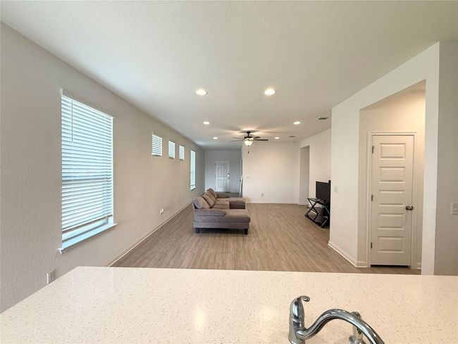 Living area featuring recessed lighting, a ceiling fan, wood finished floors, and baseboards | Image 9
