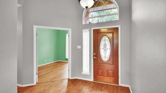 Entrance foyer featuring vinyl plank floors, a towering ceiling, and a textured wall | Image 8
