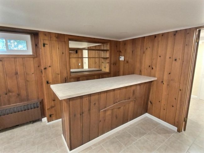 Bar area featuring wood walls and light tile patterned flooring | Image 29