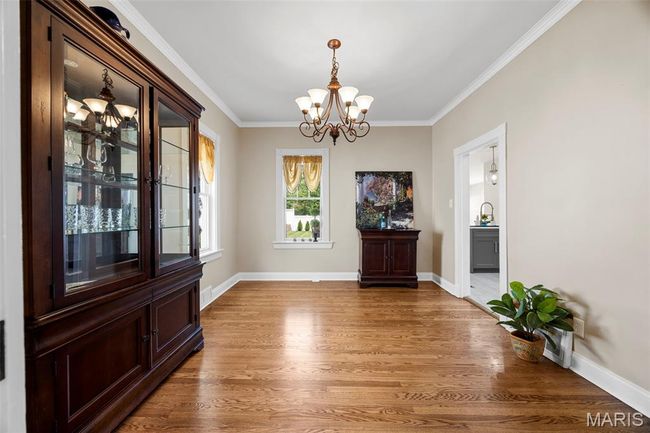 Unfurnished dining area featuring a chandelier, light wood finished floors, and crown molding | Image 5