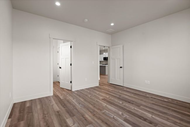 Unfurnished bedroom with recessed lighting, wood finished floors, and baseboards | Image 15