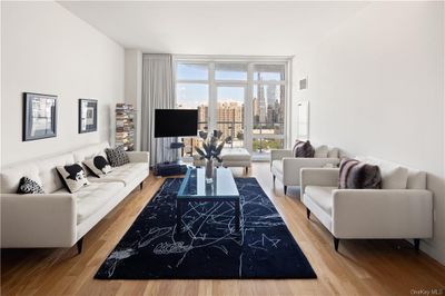 Living room with a wall of windows and light hardwood / wood-style floors | Image 1