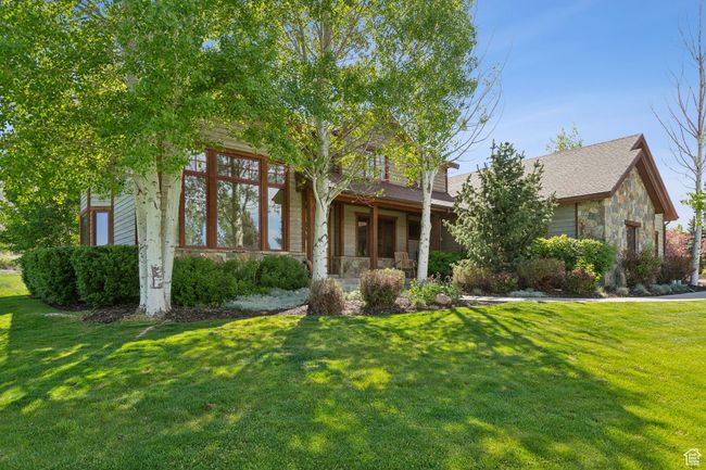 Obstructed view of property with stone siding and a front lawn | Image 65