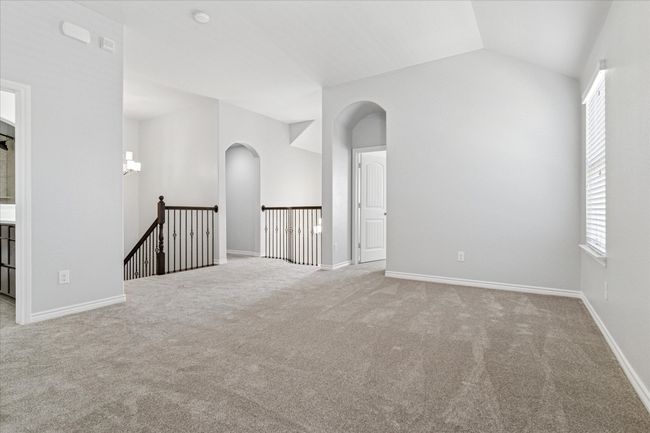 Upstairs game room featuring lofted ceiling, arched walkways, and baseboards | Image 22