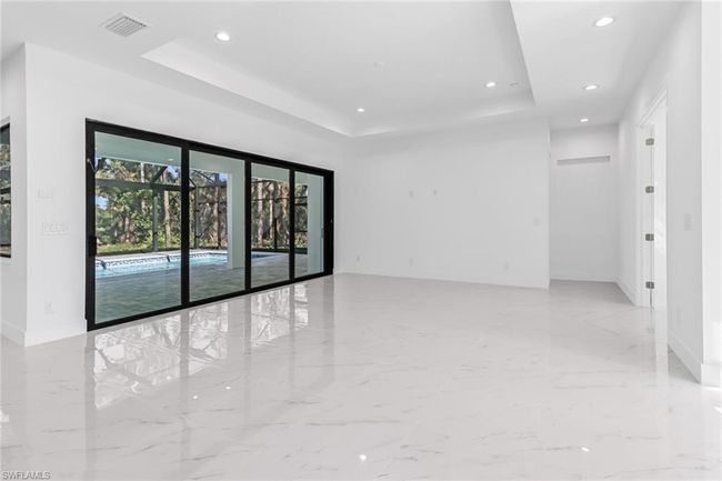 Spare room with light tile patterned floors and a tray ceiling | Image 11