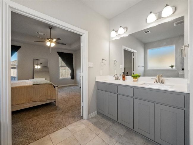 Full bath featuring a sink, tile patterned floors, connected bathroom, and double vanity | Image 16