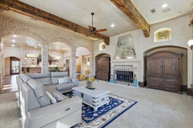 The main floor living room is open to the kitchen and casual dining space and has a door to the patio. | Image 10