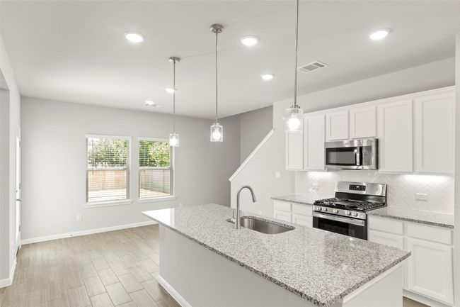 Kitchen featuring stainless steel appliances, a sink, decorative backsplash, baseboards, and recessed lighting | Image 16