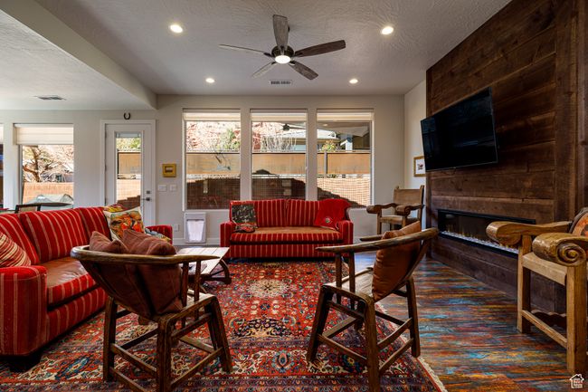 Living room with carpet flooring, a textured ceiling, a large fireplaces, and ceiling fan | Image 8