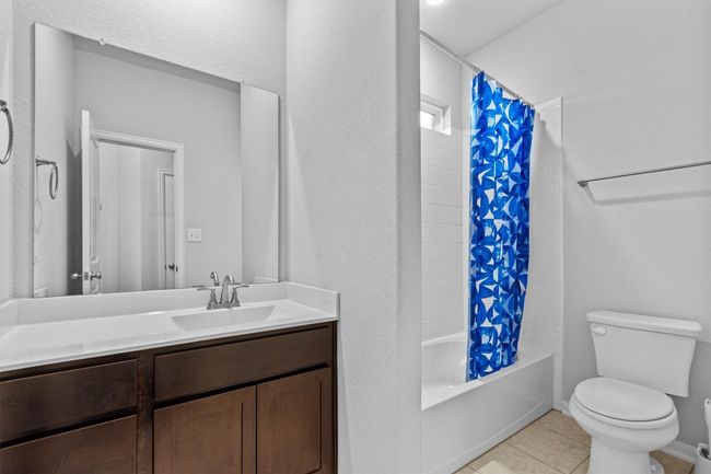 Full bathroom featuring tile patterned floors, toilet, vanity, and shower / bath combo | Image 26