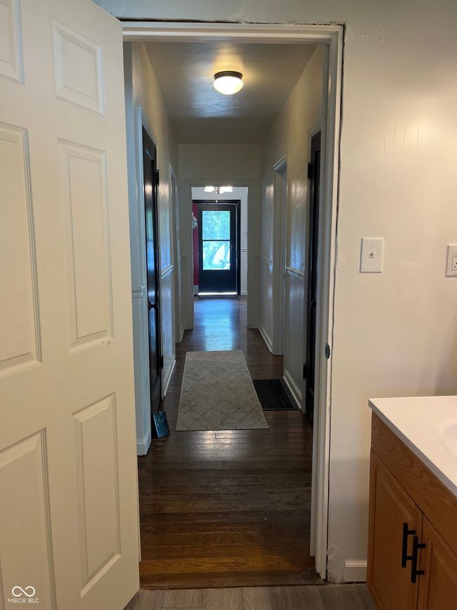 hall featuring dark wood finished floors and baseboards | Image 7