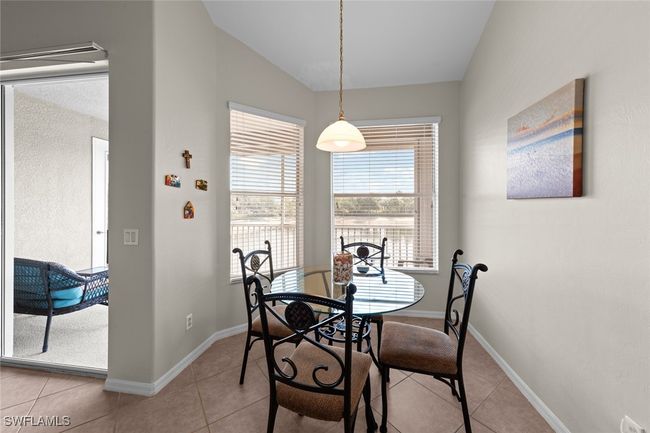 Dining area with vaulted ceiling, baseboards, and light tile patterned floors | Image 8
