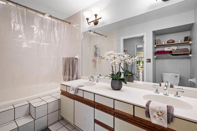 Full bathroom with double vanity, toilet, tiled shower / bath combo, and a sink | Image 13