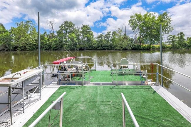 Dock area with a water view, a lawn, and view of scattered trees | Image 49