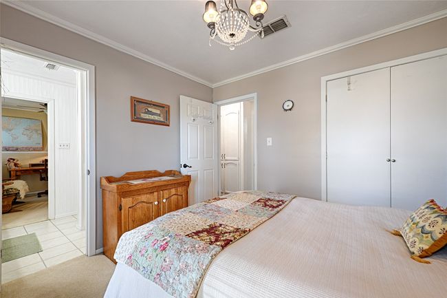 Tiled bedroom featuring a closet, a chandelier, and ornamental molding | Image 26