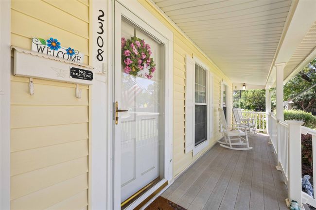 Storm door allows additional light into the living area and protects the front door. | Image 9