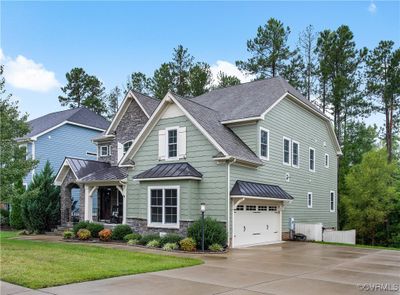 Craftsman inspired home featuring a front yard and a garage | Image 1