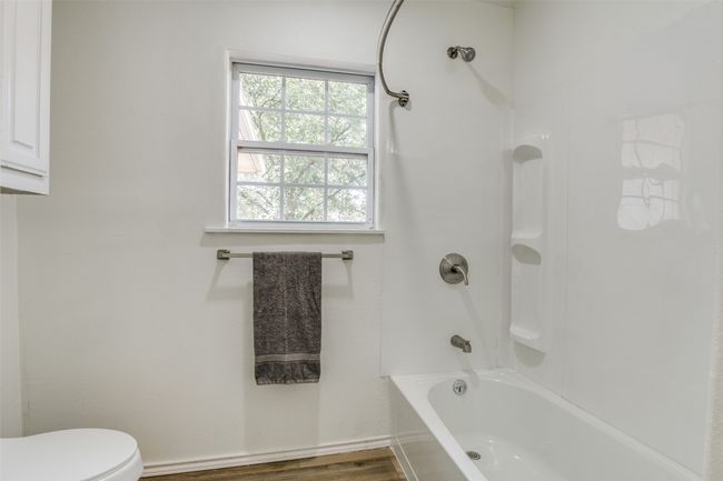 Full bath featuring washtub / shower combination and wood finished floors | Image 16