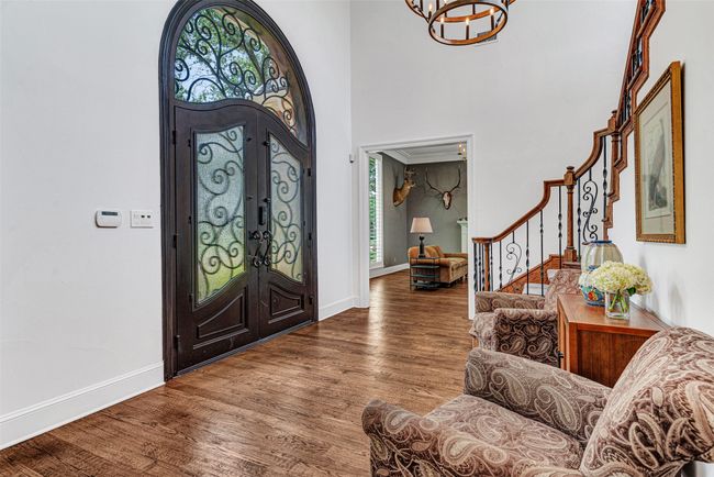 The moment you step through the impressive iron doors with leaded glass and wrought iron insets you'll know this home is exceptional. Hardwood floors have been recently refinished and set off the neutral color walls and tall ceilngs. | Image 4