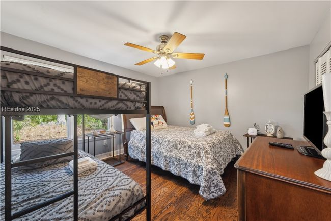 Third bedroom serves as a bunk room with a large window for beautiful natural lighting if desired, hardwood floors. Additional full size bed accomodates additonal room for sleeping. | Image 53
