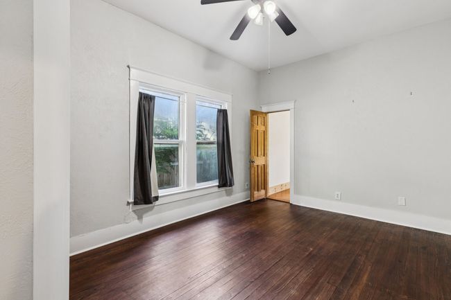 Spare room featuring wood-type flooring, baseboards, and a ceiling fan | Image 15
