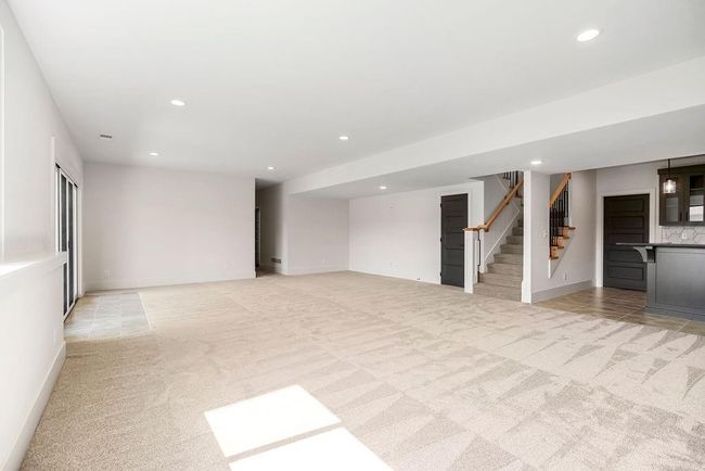 Unfurnished living room featuring light colored carpet, stairway, recessed lighting, and baseboards | Image 31