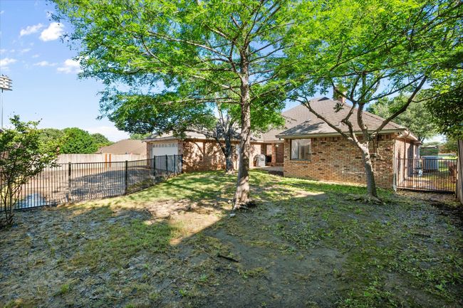 The yard has wrought iron fencing on two sided and privacy fencing on the remainder. It offers shade trees. It is ample space for a fur baby if you have one. | Image 38