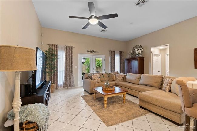 Living room featuring ceiling fan, light tile patterned floors, and french doors | Image 14