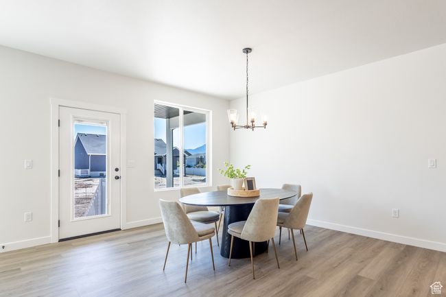 Dining area featuring a chandelier, light wood finished floors, and baseboards | Image 7