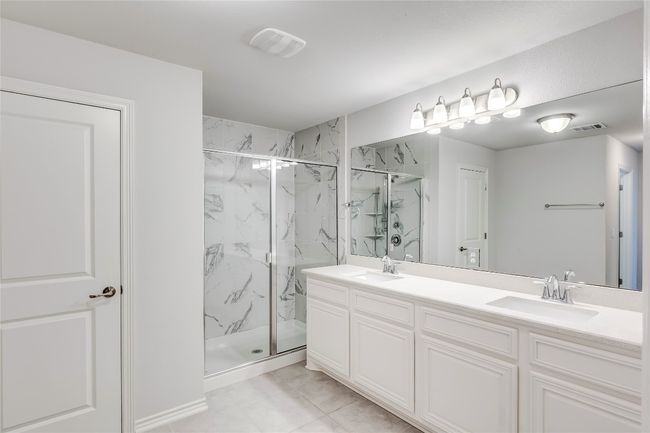 Full bathroom featuring a marble finish shower, double vanity, and marble finish floors | Image 25