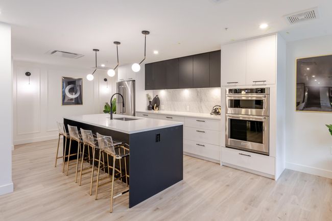 Kitchen featuring appliances with stainless steel finishes, an island with sink, modern cabinets, light wood-style floors, and recessed lighting | Image 25
