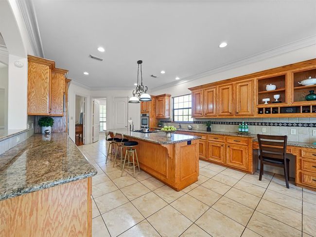 Spacious kitchen featuring a huge island with a brand new gas cooktop. | Image 19