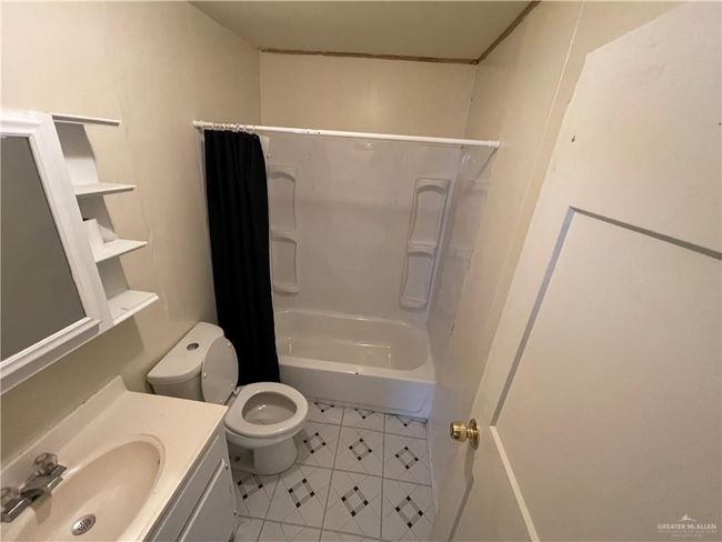 Bathroom featuring toilet, tile patterned flooring, vanity, and shower / bathtub combination with curtain | Image 15