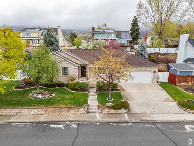View of front facade with fence, a front lawn, a residential view, an attached garage, and driveway | Image 35