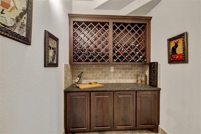 The wine room with custom wood cabinetry, granite countertops and a built-in wine rack is perfect for entertaining! | Image 20