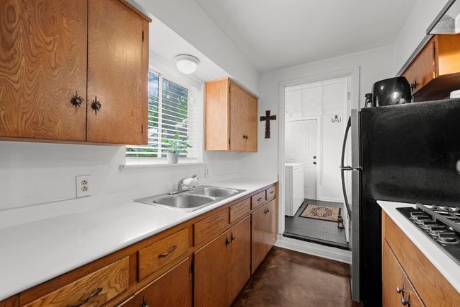 Apartment kitchen leading to laundry room and door to exterior. | Image 31