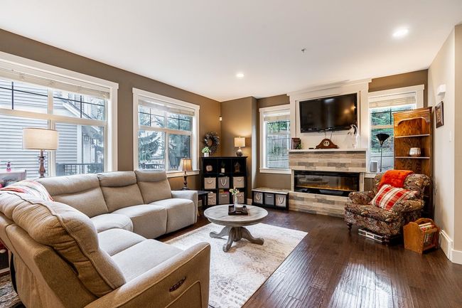 Living room featuring a stone fireplace, hardwood / wood-style flooring, recessed lighting, and baseboards | Image 4