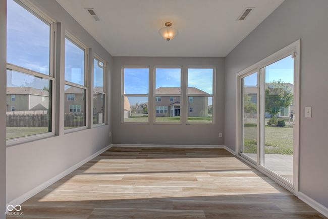 unfurnished sunroom featuring baseboards and wood finished floors | Image 23