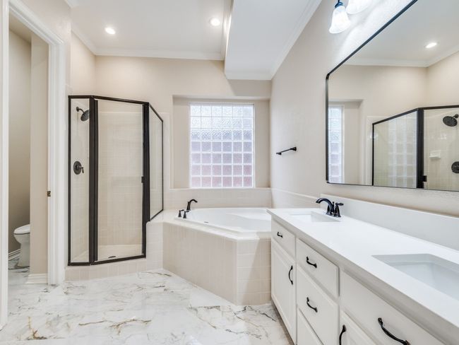 Primary bathroom with a garden tub, shower with new glass enclosure, double vanity with new marble counter with undermount sink, new mirror and recessed lighting, separate toilet area with built in. | Image 18