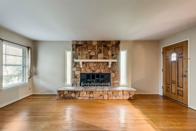 living room with baseboards, a fireplace, and wood finished floors | Image 7