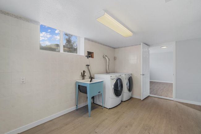 Washroom with laundry area, baseboards, light wood finished floors, and independent washer and dryer | Image 32