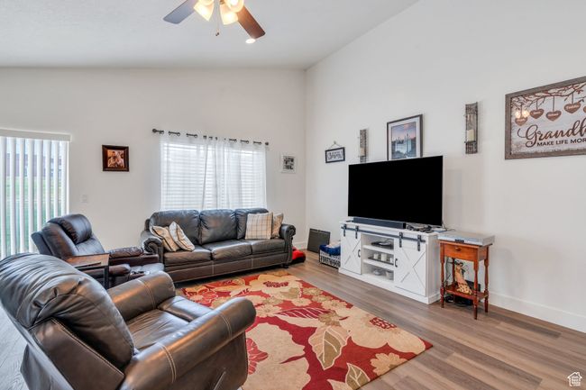 Living room featuring lofted ceiling, ceiling fan, and wood finished floors | Image 5