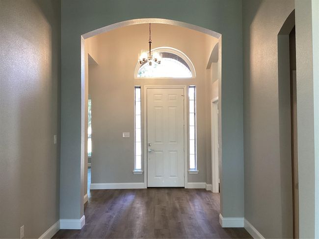Entryway featuring a chandelier, arched walkways, and dark wood-style floors | Image 4
