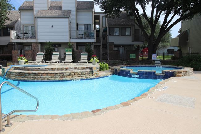 View of swimming pool with a pool with connected hot tub, fence, and a patio area | Image 26