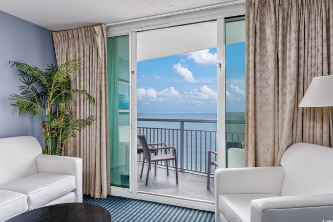 Sitting room featuring a wealth of natural light, a water view, and carpet | Image 5