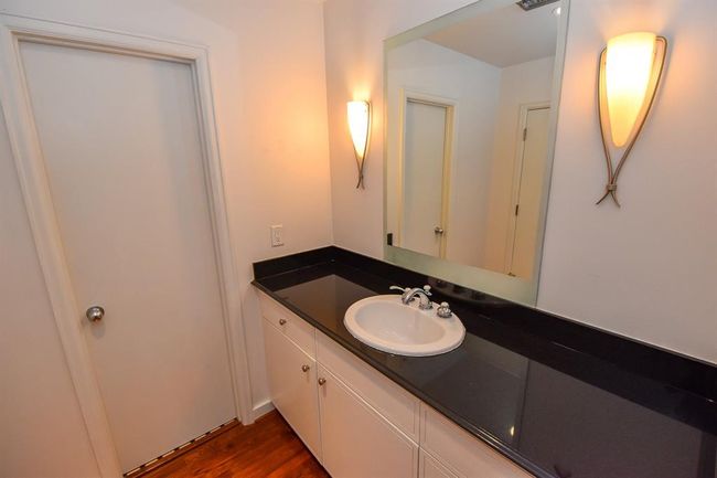 primary bathroom featuring a stylish sink and mirror with modern finishes. The clean design and ample counter space create a functional and elegant space. | Image 26