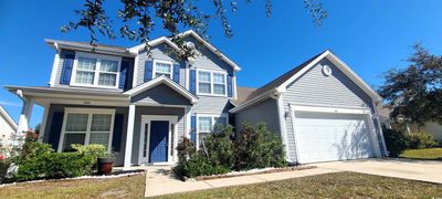 View of front of house with covered porch and a garage | Image 2