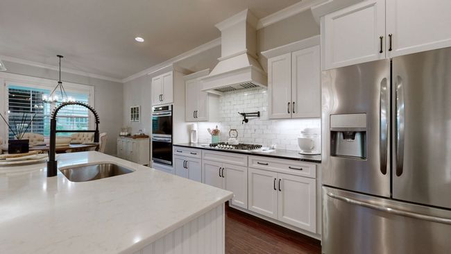 From the sleek pot filler to the quartz countertops and double ovens—this kitchen blends function and beauty for the perfect culinary space! | Image 17